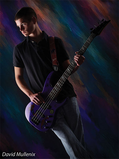 Senior portrait featuring a teen guitarist against the Meteoristic abstract photography backdrop with vibrant color energy.