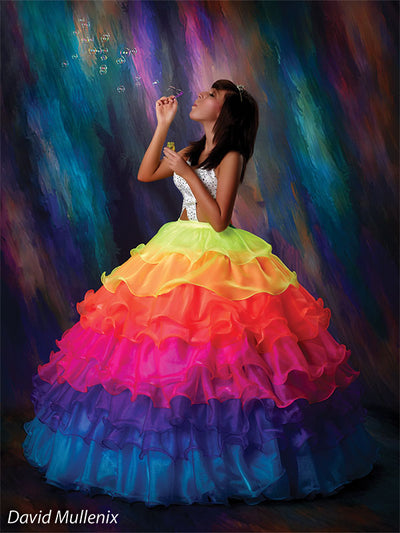 Color-rich abstract backdrop enhances this senior session featuring a vibrant rainbow gown and playful bubble details.