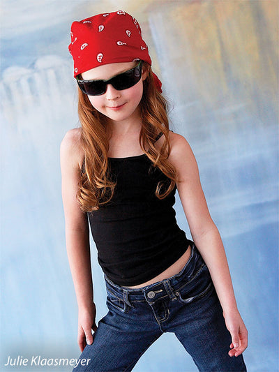 Young girl dressed playfully in front of a colorful cityscape backdrop with Venetian textures, perfect for children’s or school portraits.