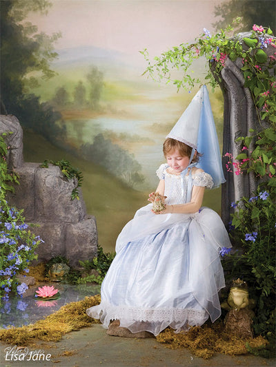 Printed Gentle Valley backdrop featuring serene nature tones, shown with a young girl model in a blue princess gown holding a frog prop.