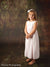 Child model standing barefoot against the Scrolled Backdrop, showcasing its scrollwork and earthy brush texture for timeless school or family photography.