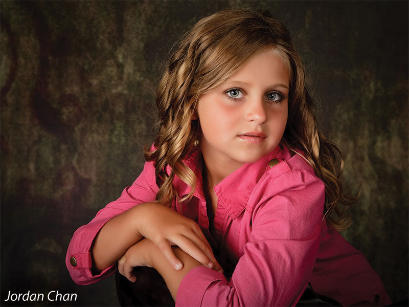 Child model in pink shirt photographed with the Scrolled Backdrop, drawing attention to its antique scroll detail and versatile tone for family portraits.