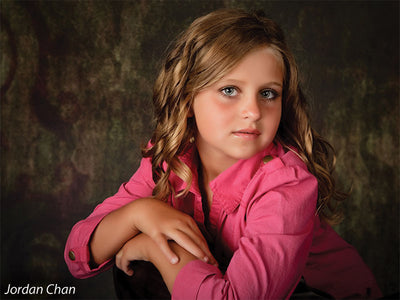 Child model in pink shirt photographed with the Scrolled Backdrop, drawing attention to its antique scroll detail and versatile tone for family portraits.