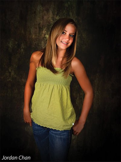 Model stands before the Scrolled Photography Backdrop, emphasizing its vintage-style scroll detail and grunge finish suitable for school portraits.