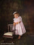 Toddler posing with vintage chair in front of the Scrolled Backdrop, highlighting its suitability for heritage-themed and heirloom portraiture.