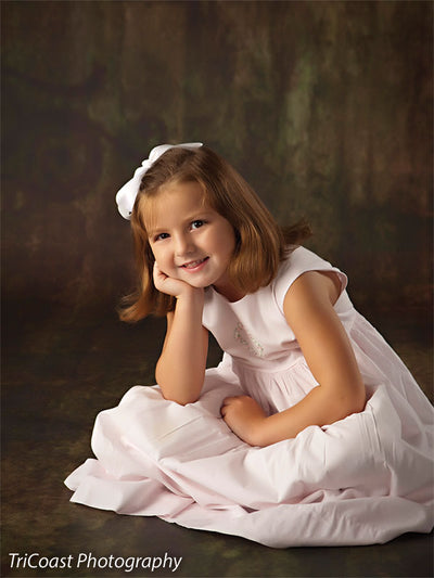 Model in a seated pose highlights the backdrop’s grunge finish and subtle scrolls, showing its versatility for soft and traditional children’s portraits.