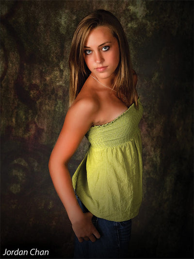 Model framed by the Scrolled Backdrop’s vintage scroll accents and mottled green-brown tones, illustrating its use in styled portrait sessions.