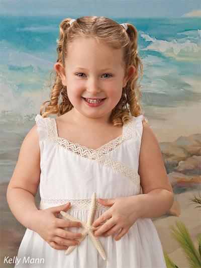 Studio photo of young girl with starfish in front of East Coast beach backdrop, ideal for themed family and portrait photography.
