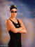 Confident swimmer in black suit posed before a golden city skyline backdrop, ideal for bold senior portraits and sports-themed sessions.
